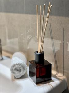 甘德尔克塞moor-home Studio Apartment的浴室提供毛巾和花瓶及棍子