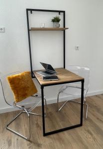甘德尔克塞moor-home Studio Apartment的一张桌子和一把椅子,上面有笔记本电脑