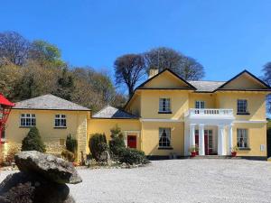 Saint CleerRosecraddoc Manor - Stable的大型黄色房屋,设有大型车道