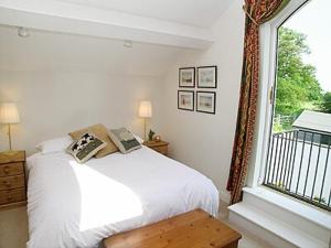 Mobberley凌晨桥农场小屋的卧室配有白色的床和窗户。