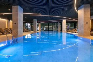 布克维HVOYA Apart-Hotel & SPA的大楼内一个蓝色的大型游泳池