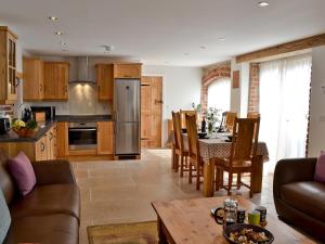 LlanddarogPaxton View Barn的厨房以及带沙发和桌子的客厅。