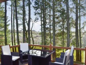 ClatworthyOak Lodge的树木繁茂的甲板上的桌椅