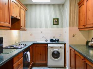 Akeld佩里温克乡村别墅的厨房配有洗衣机和水槽