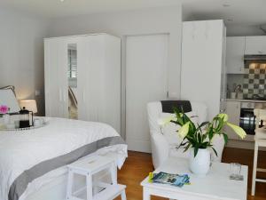 Cuckfield帕提诺乐度假屋的卧室配有白色的床和植物桌子