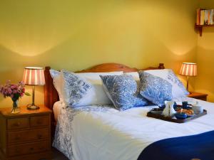赫斯特蒙苏考比奇农场度假屋的一张带蓝色和白色枕头的床,上面有托盘