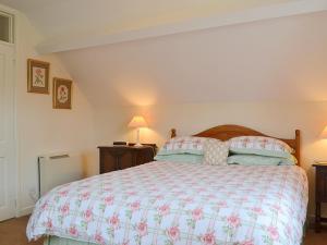 Kinlet草莓小屋乡村别墅的一间卧室配有一张大床和两盏灯。
