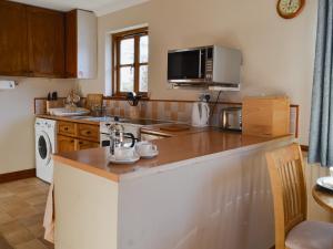 Shebbear提热拉乡村别墅的厨房配有台面和微波炉