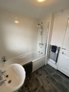 克利索普斯Seaside 2 bed Townhouse, near Cleethorpes station的白色的浴室设有水槽和淋浴。