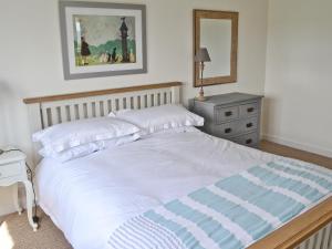 基斯高地Morys Cottage的卧室配有白色大床和梳妆台