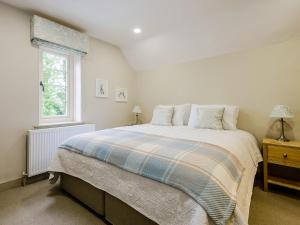 BlankneyRectory Cottage的白色的卧室设有一张大床和一个窗户