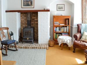 LindaleRose Cottage的客厅设有砖砌壁炉和椅子