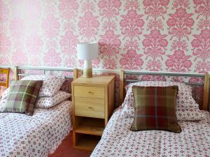LindaleRose Cottage的卧室内的两张床,配有粉红色壁纸