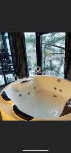 AukštkiemiaiExclusive Jacuzzi Apartaments Klaipėda的窗户客房内的大浴缸