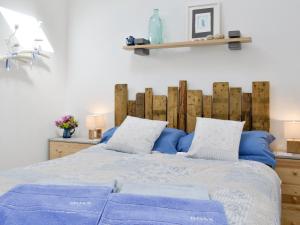 Wrangaton菲格瑞度假屋的一间卧室配有一张带蓝色床单和枕头的床。
