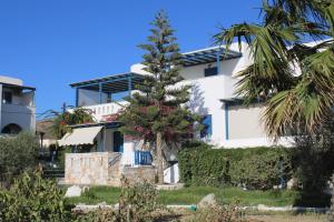 米科利维亚Crystal Naxos 1 Studios at Mikri Vigla的白色建筑前的棕榈树