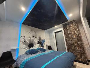 埃皮纳勒Butterfly By Carl-Emilie的一间卧室配有一张带蓝色灯光天花板的床