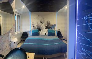 埃皮纳勒Butterfly By Carl-Emilie的一间卧室配有一张带蓝色枕头的大床
