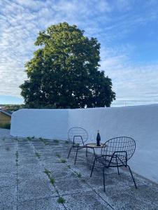 哥德堡Luxurious villa with free parking的白色墙壁前的两把椅子和一张桌子