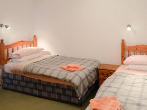 约翰奥格罗茨Mill Cottage的一间卧室配有两张床和床上的浴袍。