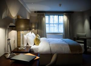 林肯Castle Hotel & Apartments的配有一张床、一张书桌和一扇窗户的酒店客房
