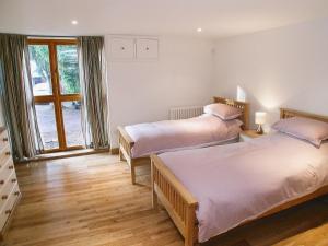 Drayton农场谷仓街乡村别墅的一间卧室设有两张床和窗户。