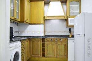 圣维森特-德拉巴尔克拉APARTAMENTO BARLOVENTO的厨房配有木制橱柜、洗衣机和烘干机