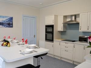 KirtlebridgeBonshawside Farmhouse的厨房配有白色橱柜和白色台面