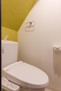 东京Great Access to Shibuya/Shinjuku-Gracias Shibuya的浴室设有白色卫生间和黄色墙壁。