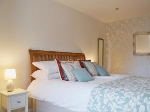 CeresWell Cottage的卧室配有带枕头的大型白色床