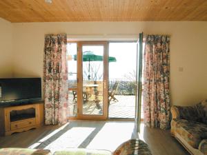 彭代恩Seacrest Cottage - Hw7746的带沙发和滑动玻璃门的客厅