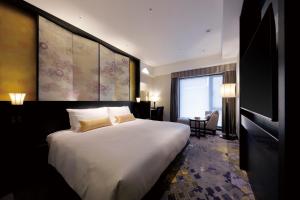 金泽金泽山乐酒店的酒店客房设有一张大床和一张书桌。