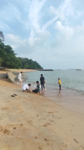 马六甲Mutiara Chalet的一群人在海滩上玩耍