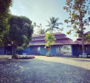 清迈LPL Resort的一座蓝色的建筑,前面有棕榈树