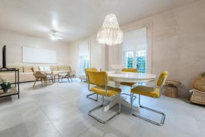 马拉加Exclusivo Bajo frente al mar - Playa la Caleta的客厅配有白色桌子和黄色椅子