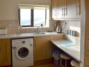 FlashNield Bank Bungalow的厨房配有洗衣机和水槽