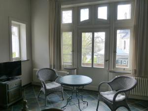 汉诺威托斯卡别墅酒店的客厅配有桌椅和窗户。