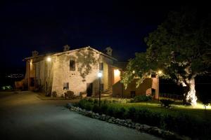 Castel Ritaldi拉特奴塔棣里科尔迪酒店的一座在晚上有树的大型石头建筑