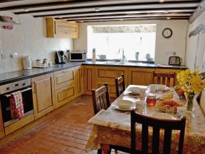 KentisbeareFolly Cottage的一间带桌椅的厨房和一间带桌子的厨房