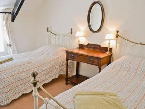 KentisbeareFolly Cottage的一间卧室配有两张床和一张带镜子的桌子