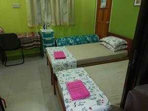淡文HOMESTAY JANNATI TAMBUN的一间设有两张床和两张桌子的房间