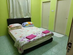 淡文HOMESTAY JANNATI TAMBUN的一间卧室配有带粉红色枕头的床。