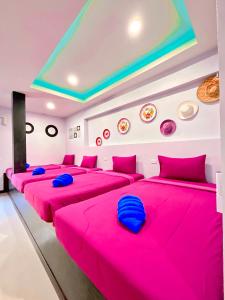 功孟海滩Sea Smile Green View Pool Villa KRABI Klong Muang的一间设有四张床和粉红色床单的客房