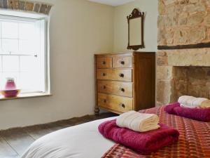 LlandybieThe Mill Farmhouse的一间卧室配有带毛巾的床