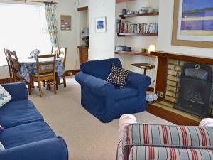 彭赞斯小蓝屋乡村别墅的客厅设有蓝色的沙发和壁炉