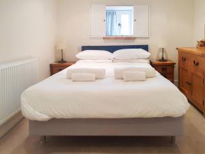 海滨韦尔斯港Madeleines Barn的一张白色的大床,上面有两个白色的枕头