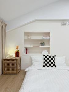 台南白色苏打的白色卧室,配有带 ⁇ 格枕头的床
