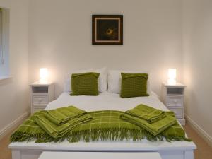 格拉斯米尔客栈度假屋的卧室配有白色床和绿毯