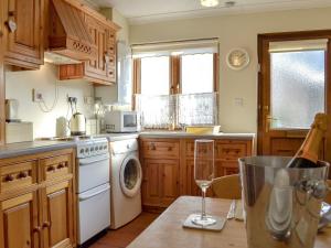 阿伯加文尼德雷格度假屋的厨房配有白色炉灶烤箱,旁边设有洗碗机