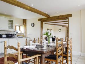 DingestowWhite Hill Farm Cottage的厨房以及带木桌和椅子的用餐室。
